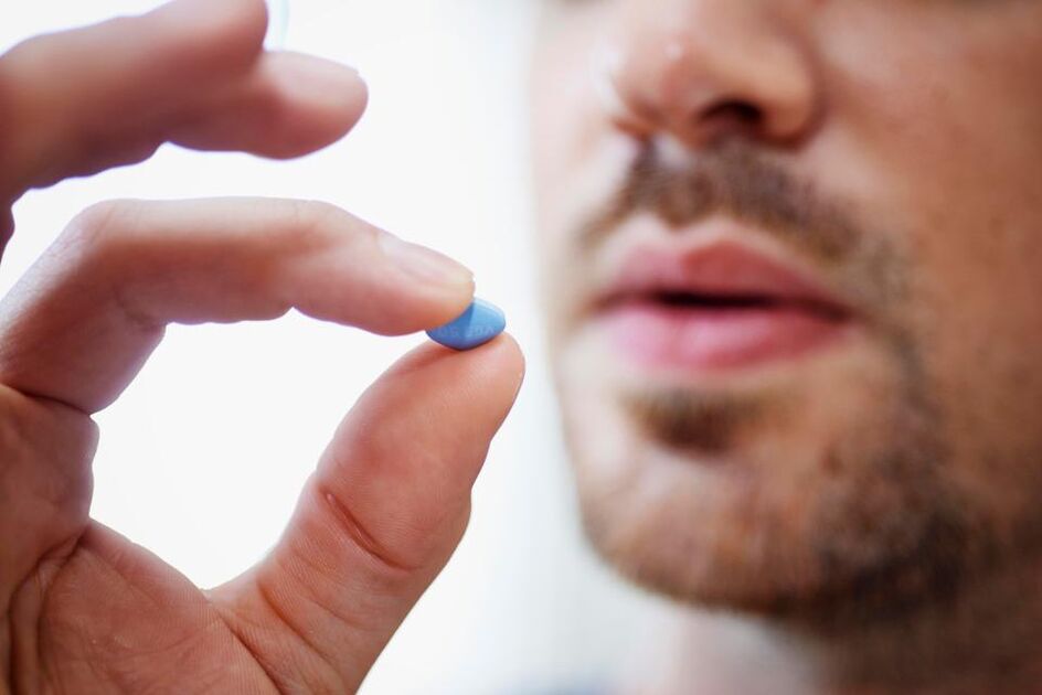 vīrietis iedzer tableti, lai stimulētu potenci
